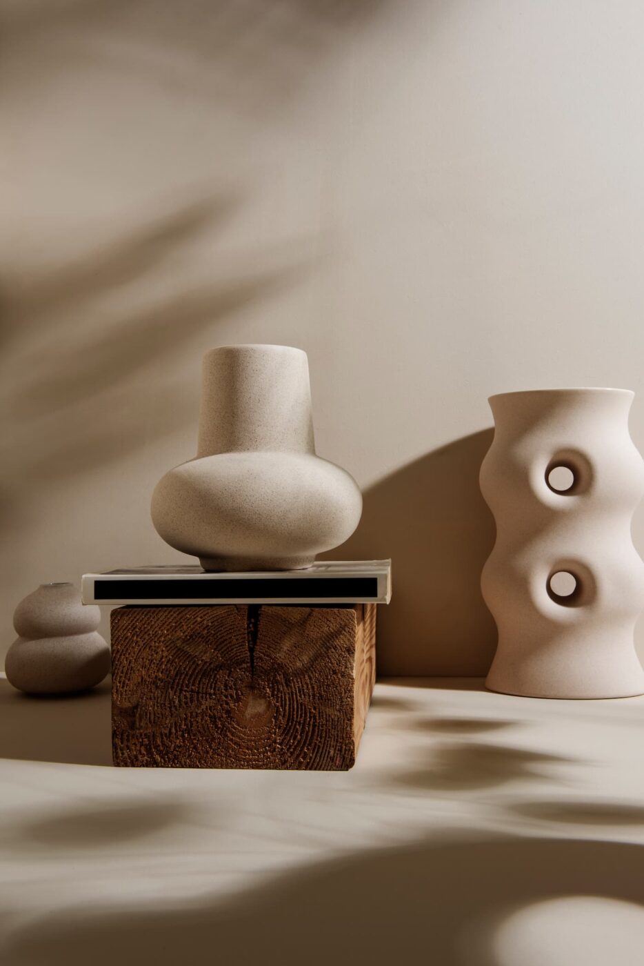 vases déco avec formes organiques posées sur un bloc de bois brut esprit minimaliste